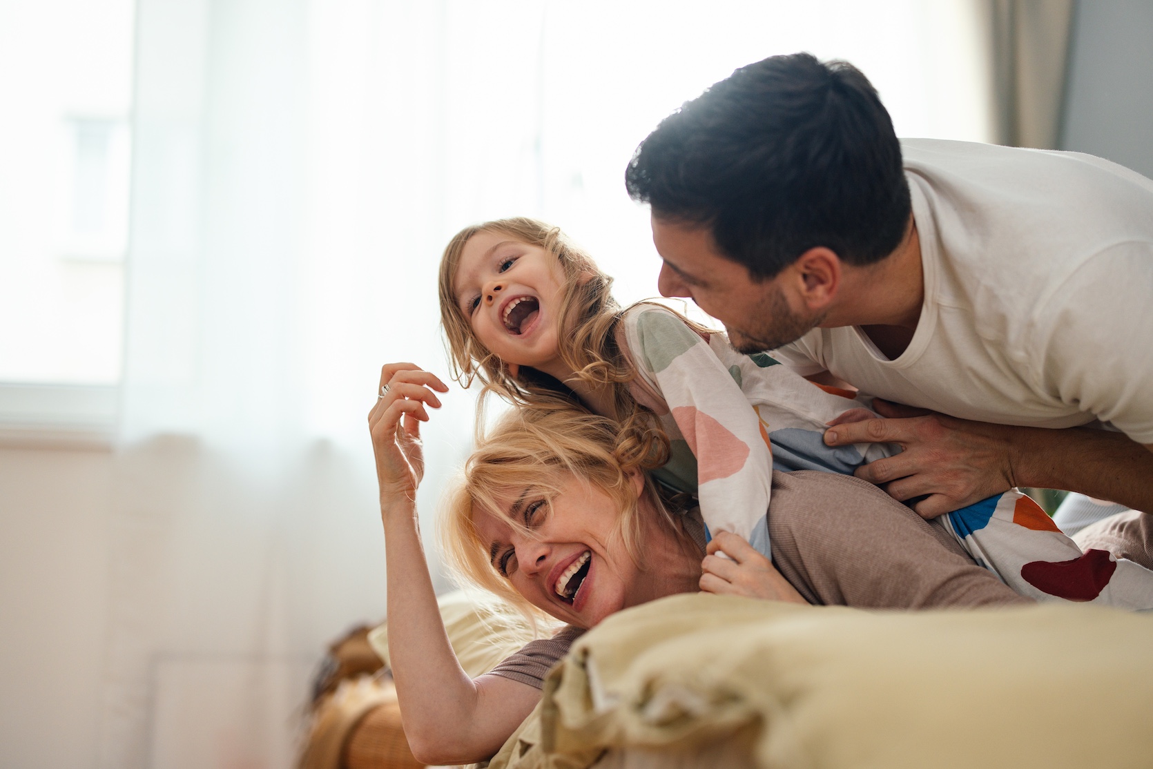 Happy family - mother, father and daughter laughing together
